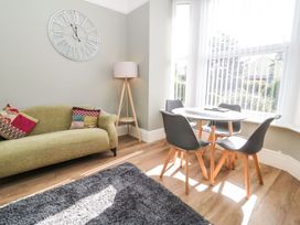 A living room with a clock on the wall at Flat 1A, Mona House in Conwy