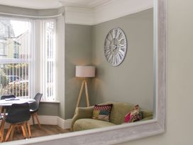 A living room with a sofa and floor lamp at Flat 1A, Mona House in Conwy