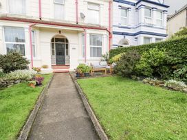 A garden with a pathway and seating area at Flat 1, Mona House in Conwy