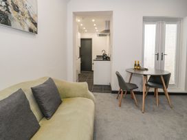 A living room with a sofa and dining table at Flat 1, Mona House in Conwy