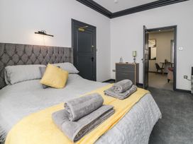 A bedroom with a bed and nightstand at Flat 1, Mona House Conwy