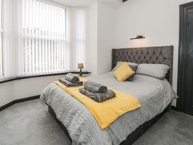 A bedroom with a bed and towels at Flat 1, Mona House in Conwy