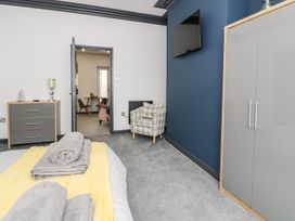 A bedroom with a bed and a dresser at Flat 1, Mona House Conwy