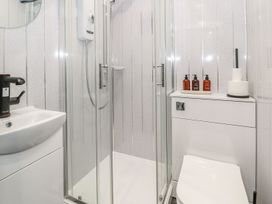 A bathroom with shower, sink, and toilet at Flat 1, Mona House, Conwy
