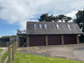 A garage building with a deck area at Hayes Lodge Coach House in Chulmleigh