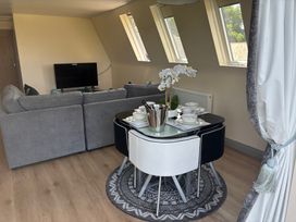 A living room with a sofa and dining table at Hayes Lodge Coach House in Chulmleigh
