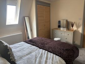 A bedroom with a bed and dresser at Hayes Lodge Coach House in Chulmleigh