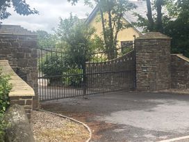 A gate in a stone wall with vegetation surrounding it at Hayes Lodge Coach House Ashreigney near Dolton