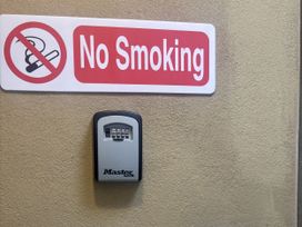 No Smoking sign and a Master Lock mounted on the wall at Hayes Lodge Coach House Ashreigney near Dolton