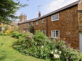 A house with a garden and flowers at Magdalen Cottage in Hook Norton