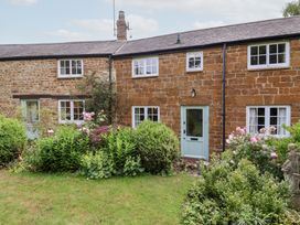 A stone cottage with a front garden at Magdalen Cottage, Hook Norton