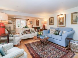 A living room with a sofa and armchair at Magdalen Cottage in Hook Norton