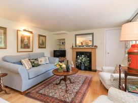 A living room with a sofa and table at Magdalen Cottage in Hook Norton