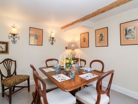 A dining room with a table and chairs at Magdalen Cottage, Hook Norton