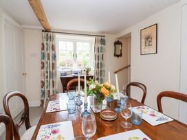 A dining room with a table and chairs at Magdalen Cottage in Hook Norton
