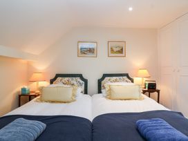A bedroom with two single beds and lamps at Magdalen Cottage in Hook Norton