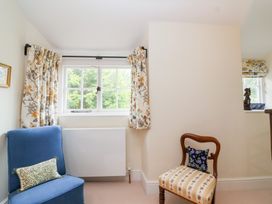 A sitting room with a blue chair and a brown chair at Magdalen Cottage in Hook Norton
