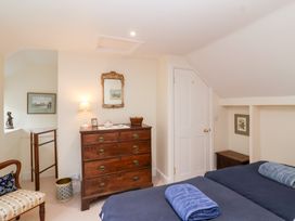 A bedroom with a bed and chest of drawers at Magdalen Cottage in Hook Norton