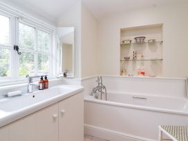 A bathroom with a bathtub and sink at Magdalen Cottage in Hook Norton