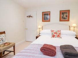 A bedroom with a bed and two bedside lamps at Magdalen Cottage in Hook Norton
