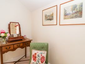 A dressing room with a vanity table and armchair at Magdalen Cottage in Hook Norton