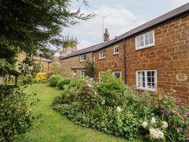 A house with a garden and flowers at Magdalen Cottage in Hook Norton