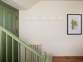 A hallway with a green door and a coat hook at Apartment 1, 86 Dyer Street Cirencester