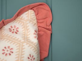A cushion against a blue wall at Apartment 1, 86 Dyer Street Cirencester