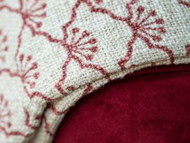 A close-up of fabric draped over a red sofa at Apartment 1, 86 Dyer Street Cirencester