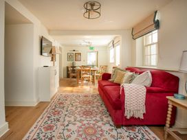A living room with a sofa and dining area at Apartment 1, 86 Dyer Street Cirencester