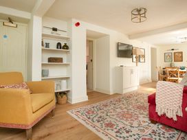 A living room with an armchair and television at Apartment 1, 86 Dyer Street Cirencester