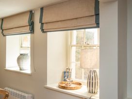 Two windows with curtains and decor items at Apartment 1, 86 Dyer Street Cirencester