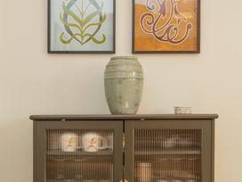 A cabinet with a vase and framed art at Apartment 1, 86 Dyer Street Cirencester