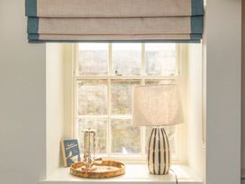 A living room with a window and lamp at Apartment 1, 86 Dyer Street Cirencester