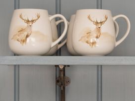 Two mugs with a deer design on a shelf at Apartment 1, 86 Dyer Street Cirencester
