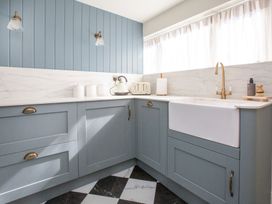 A kitchen with a sink, cabinets and appliances at Apartment 1, 86 Dyer Street Cirencester