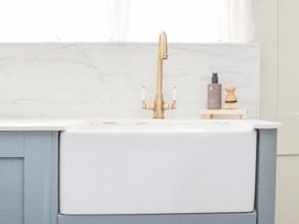 A kitchen sink with a faucet and soap dispenser at Apartment 1, 86 Dyer Street in Cirencester