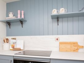 A kitchen with countertop and shelves holding utensils at Apartment 1, 86 Dyer Street, Cirencester