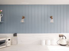 A kitchen with a microwave, knife block, and canisters at Apartment 1, 86 Dyer Street, Cirencester