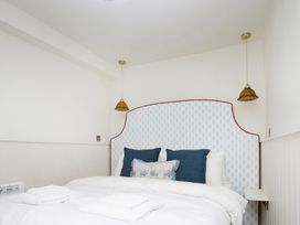 A bedroom with a bed and light fixtures at Apartment 1, 86 Dyer Street Cirencester
