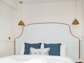 A bedroom with a bed and decorative pillows at Apartment 1, 86 Dyer Street Cirencester