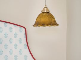 A lamp hanging above a bed in Apartment 1, 86 Dyer Street Cirencester