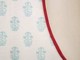 A fabric with a blue pattern and red trim