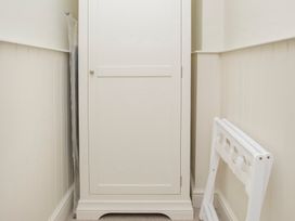 A wardrobe and an umbrella in a hallway at Apartment 1, 86 Dyer Street Cirencester