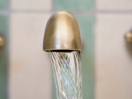 A faucet with flowing water at Apartment 1, 86 Dyer Street Cirencester