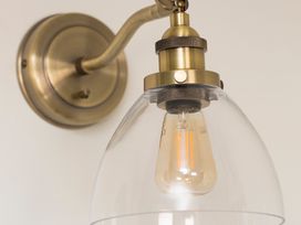 A light fixture with a brass mount and glass shade at Apartment 1, 86 Dyer Street Cirencester