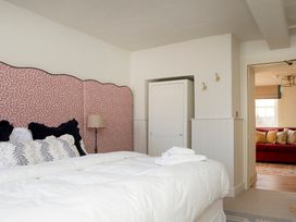 A bedroom with a bed and wardrobe at Apartment 1, 86 Dyer Street in Cirencester