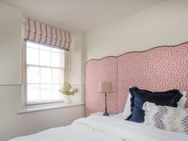 A bedroom with a bed and decorative pillows at Apartment 1, 86 Dyer Street Cirencester