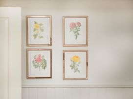 Four framed flower illustrations on a wall at Apartment 1, 86 Dyer Street in Cirencester