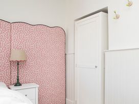 A bedroom with a lamp and nightstand at Apartment 1, 86 Dyer Street Cirencester
